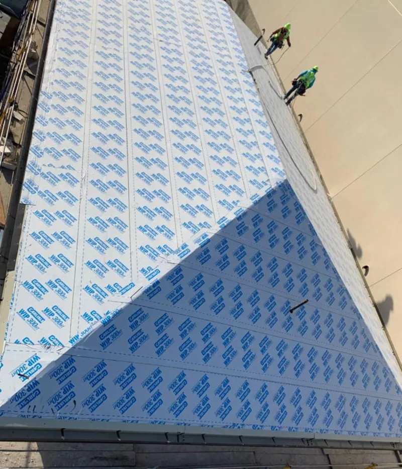 Professional roofers installing underlayment on a metal roof in Madison